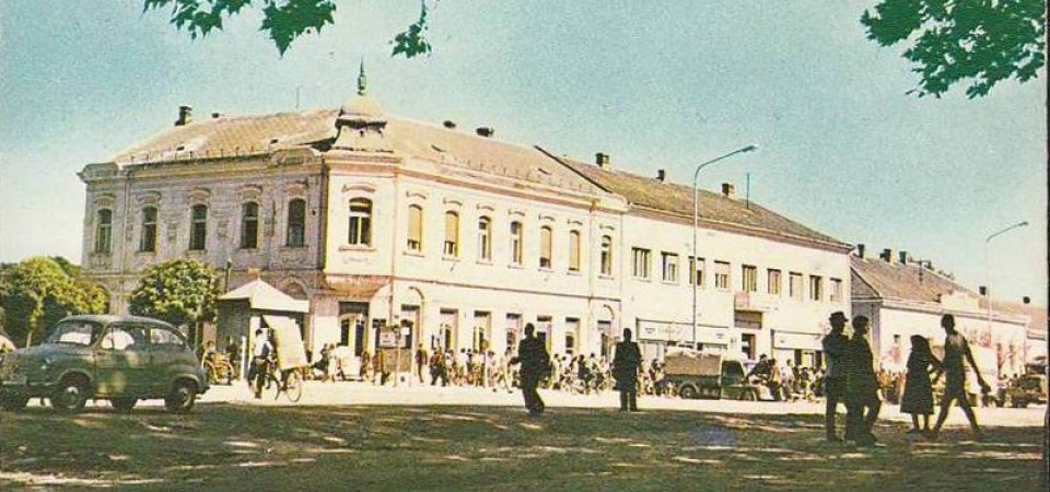 Na staroj fotografiji s druge polovine 20. veka vidi se centar Stare Pazove, ljudi, automobili itd.